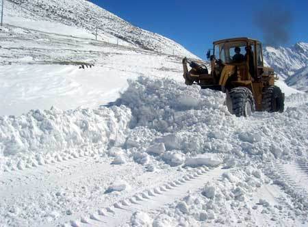 A bulldozer cleans snow on the Sichuan-Tibet road in Nyingchi, southwest China's Tibet Autonomous Region Oct. 30, 2008. (Xinhua Photo)