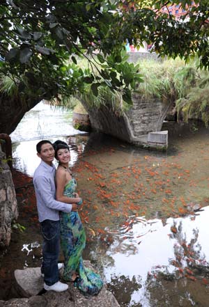 This photo dated on Oct. 24, 2008 shows a couple pose for wedding photos in ancient Lijiang city, southwest China's Yunnan Province. [Xinhua]