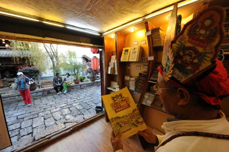 This photo dated on Oct. 23, 2008 shows an old Naxi man reads a Dongba book in ancient Lijiang city, southwest China's Yunnan Province. [Xinhua]