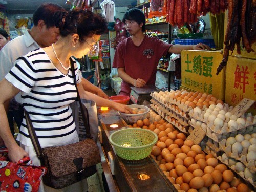 People choose eggs in a supermarket of Guangzhou, Guangdong Province, on November 1, 2008. The Ministry of Agriculture has carried out inspections on feed manufacturers nationwide to root out those found using excessive amounts of the chemical melamine after exposure of tainted milk and eggs scandals.