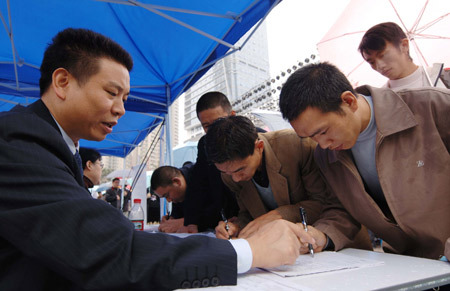 Migrant workers fill in application forms at a job fair in Chongqing, southwest China on Jan. 1, 2008. International Labor Organization (ILO) estimated earlier that the financial crisis would cost 20 million jobs globally by the end of 2009. (Xinhua Photo)