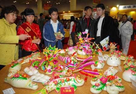Visitors look at the traditional dough modellings during the third China International Food Festival kicked off Saturday in Yantai, east China's Shandong Province, November 1, 2008. (Xinhua Photo) 
