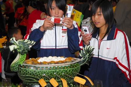 Two students take photos of a finest dish on display during the third China International Food Festival kicked off Saturday in Yantai, east China's Shandong Province, November 1, 2008. (Xinhua Photo) 