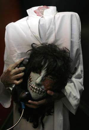 A boy dressed in Halloween costume plays with a phone before a contest during a trick or treat event in a mall in Quezon City, Metro Manila October 26, 2008.