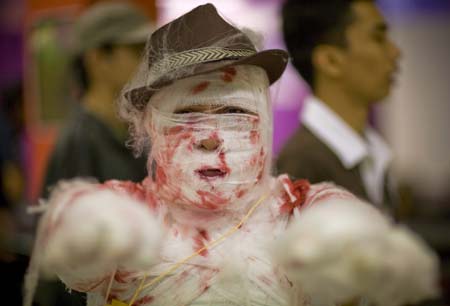 A contestant who is participating as a Mummy poses before the start of a Halloween costume contest inside an amusement park in Manila October 31, 2008. 