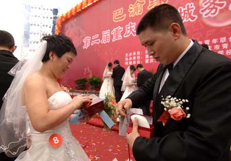 Newly-weds of migrant workers exchange wedding presents during a group wedding in southwest China&apos;s Chongqing Municipality, Nov. 2, 2008. 