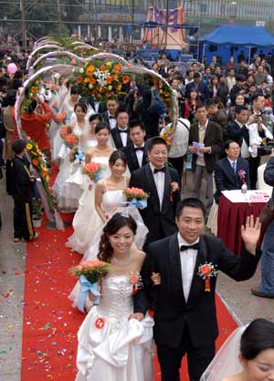 Newly-weds of migrant workers walk on red carpet during a group wedding in southwest China&apos;s Chongqing Municipality, Nov. 2, 2008. 