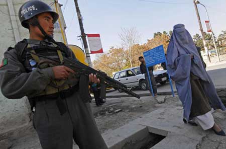 An Afghan policeman stands guard near the street where a French aid worker was kidnapped on Nov. 3.