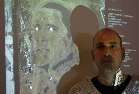 U.S. artist Jorge Rodriguez-Gerada poses next to a projected image of an aerial view of the face of U.S. Democratic presidential nominee Senator Barack Obama (D-IL), during a news conference in a hotel in Barcelona November 3, 2008.