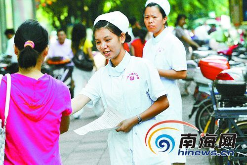 Medical workers organized by Hainan provincial sanitation and anti-epidemic departments send leaflets to local people, publicizing the knowledge of prevention of cholera, on November 2, 2008. 