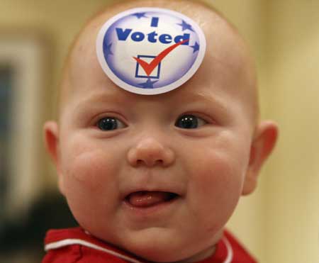 Six-month-old baby Liam Greer from Ohio with a I Vote sticker on his forehead smiles during an election night in Amman November 4, 2008. 