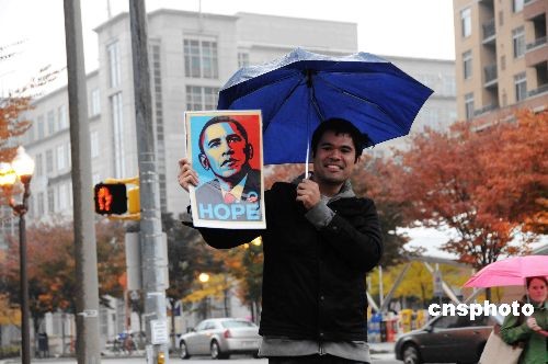 In Washington D.C an Obama supporter holds up a portrait of the Democratic Presidential Candidate with the message &apos;Hope&apos;. [China News Service]