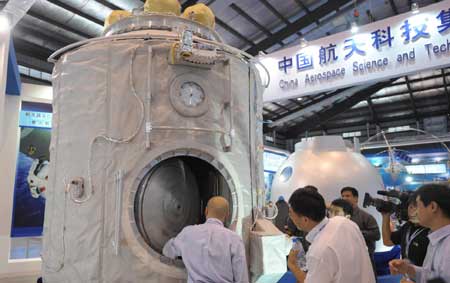  Visitors look at a spare space module of the Shenzhou-7 at the 7th China International Aviation and Aerospace Exhibition in Zhuhai, south China&apos;s Guangdong Province, Nov. 3, 2008. 