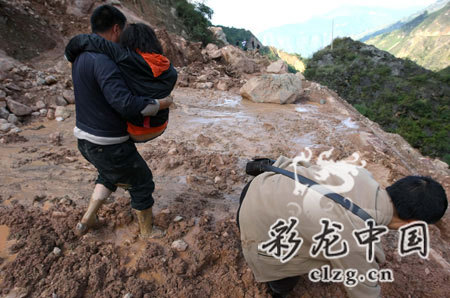 Local villagers walk on a road destroyed by mud-rock flows in Kunming, the capital of southwest China's Yunnan Province in the photo published on Tuesday, November 4, 2008. [Photo: clzg.cn]