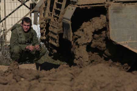 An Israeli soldier rests near a tank on the Israel Gaza border, Nov. 5, 2008. Six Palestinians were killed in a clash between Palestian militants and Israeli soldiers on Wednesday morning in central Gaza Strip.