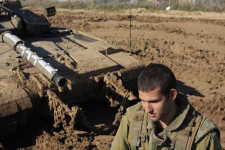 An Israeli soldier rests near a tank on the Israel Gaza border, Nov. 5, 2008. 