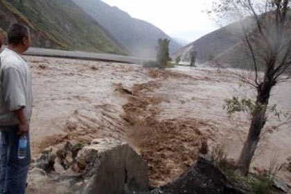 A farmer looks on as rising flood waters overflow onto a road near Kunming. [Agencies via China Daily] 