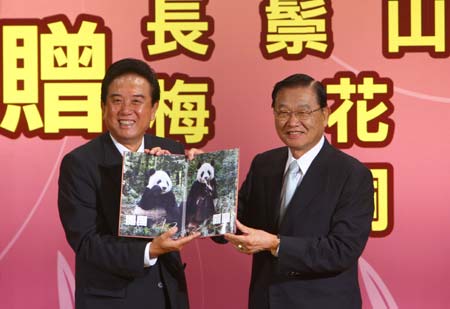 Chief of mainland's Association for Relations Across the Taiwan Straits (ARATS) Chen Yunlin (L) shows a picture of the giant panda pair that the mainland promised to donate to Taiwan three years ago with Taiwan-based Straits Exchange Foundation (SEF) Chairman Chiang Pin-kung during a press conference in Taipei, southeast China's Taiwan Province, Nov. 6, 2008. 