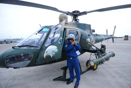 A pilot stands nearbay a homemade Z-11 armed helicopter during the Zhuhai Air Show, November 5, 2008. Z-11 is a type of light observation and armed helicopter built in China. 