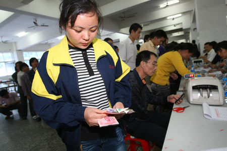 A former employee of the Weixu Shoe company picks up her wages from the Chang'an government on Tuesday. [China Daily] 