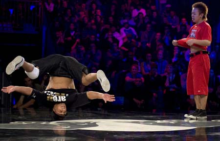 Lil Ceng (L) of Germany performs as Taisuke of Japan watches during the Red Bull BC One break-dance competition, in which 16 B-Boys from across the world compete in one-on-one knockout battles to determine the winner, in Paris November 5, 2008. [Xinhua/Reuters]