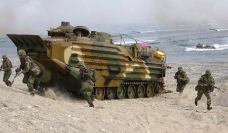Members of the South Korean Marine Corps run in front of the amphibious assault vehicle during the U.S.- South Korea joint amphibious landing operation drill along the shore in Pohang, about 370 km (230 miles) southeast of Seoul, November 6, 2008.