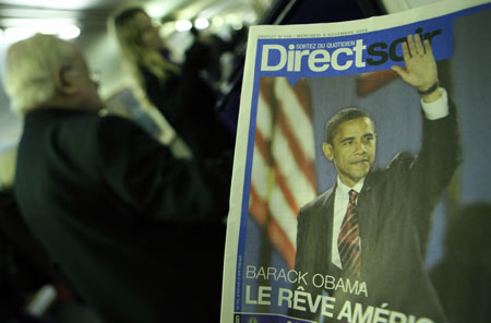 Passengers get the free newspaper with news of Barack Obama being elected to be the next U.S. president on the underground in Paris, France, Nov. 5, 2008. French public showed great concern for Tuesday's U.S. election, and the French media put the news of the U.S. election on their front pages. [Xinhua]