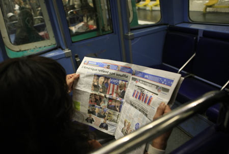 A passenger reads news of Barack Obama being elected to be the next U.S. president on a newspaper on the underground in Paris, France, Nov. 5, 2008. French public showed great concern for Tuesday's U.S. election, and the French media put the news of the U.S. election on their front pages. [Xinhua]
