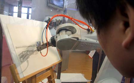 A visitor watches a robot painting a picture at the 2008 Shanghai International Industry Fair opened in Shanghai, China, Nov. 4, 2008. Covering an area of over 120,000 square meters, the exhibition attracted a total of 1816 companies from 25 countries and regions, and served as the largest of its kind in history as the fair has come to its 10th year.