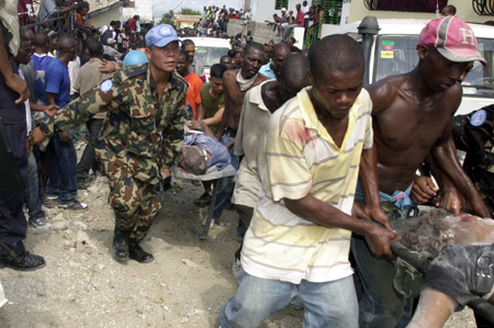 Rescuers try to save the injured in a collapsed church-operated school in Haiti Friday. The school collapsed during the class time. (Xinhua/AFP Photo)