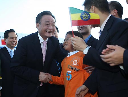 Wu Bangguo (L Front), chairman of the Standing Committee of China&apos;s National People&apos;s Congress, the country&apos;s top legislature, shakes hands with a boy greeting him at the airport in Addis Ababa, capital of Ethiopia, Nov. 8, 2008. Wu Bangguo arrived in Addis Ababa for an official goodwill visit to Ethiopia on Nov. 8.