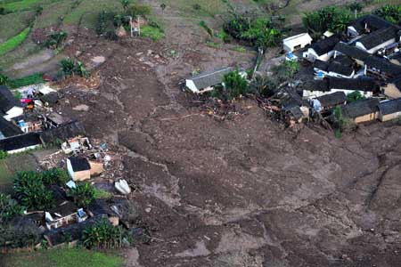 The aerial view photo taken on Nov. 6, 2008 shows the Dasongshu Village of Xishelu Township in Chuxiong Yi Autonomous Prefecture of southwest China&apos;s Yunnan Province is dived into two by the landslide. Chuxiong is one of the worst-hit areas in the rain-triggered disasters that are known to have killed 40 people so far. Some villages in Chuxiong were completely isolated after roads were cut off by the landslides and mud-flows over the past 10 days. Helicopters began to airdrop relief materials to the isolated areas on Thursday. The geological disasters that followed almost 10 days of rain also left 43 others missing, 10 injured and 60,800 evacuated in Yunnan, with about 1.27 million people in nine cities and prefectures affected.(Xinhua/Chen Haining) 