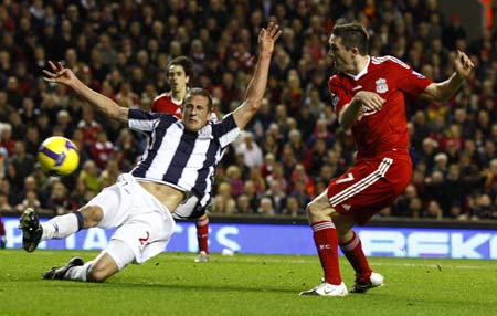 Liverpool&apos;s Robbie Keane (R) shoots past West Bromwich Albion&apos;s Jonas Olsson to score his first goal during their English Premier League soccer match in Liverpool, northern England, November 8, 2008.