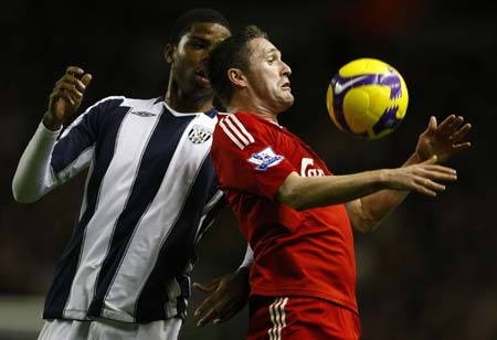 Liverpool&apos;s Robbie Keane (R) challenges West Bromwich Albion&apos;s Ryan Donk during their English Premier League soccer match in Liverpool, northern England, November 8, 2008.