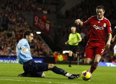 Liverpool&apos;s Robbie Keane (R) takes the ball round West Bromwich Albion&apos;s goalkeeper Scott Carson to score his second goal during their English Premier League soccer match in Liverpool, northern England, November 8, 2008.