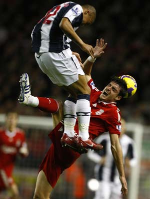 Liverpool&apos;s Albert Riera (R) challenges West Bromwich Albion&apos;s Gianni Zuiverloon during their English Premier League soccer match in Liverpool, northern England, November 8, 2008.