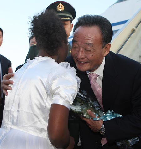 Wu Bangguo (R), chairman of the Standing Committee of China's National People's Congress, the country's top legislature, hugs the girl presenting flowers to him at the airport in Addis Ababa, capital of Ethiopia, Nov. 8, 2008. Wu Bangguo arrived in Addis Ababa for an official goodwill visit to Ethiopia on Nov. 8. [Xinhua]