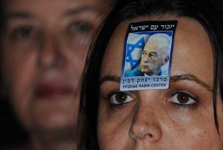  A woman with a sticker of late Israeli Prime Minister Yitzhak Rabin attends a rally for a memorial service marking the 13th anniversary of the assassination of Rabin at the square where he was assassinated in Tel Aviv, Israel, Nov. 8, 2008. Some 50,000 people attended the memorial rally on Saturday night. 