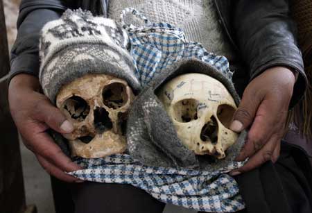 A woman carries skulls to a church during a ceremony on the Day of Skulls in the General Cemetery of La Paz November 8, 2008. 