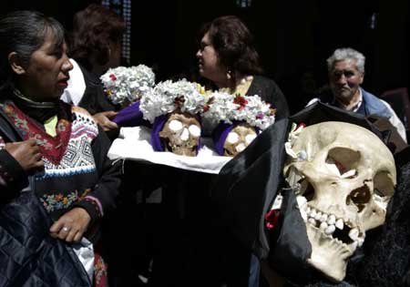 Devotees carry skulls during a ceremony on the Day of Skulls at a church in the General Cemetery of La Paz November 8, 2008.