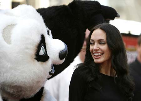 Cast member Angelina Jolie poses with a panda character during the DVD release of 