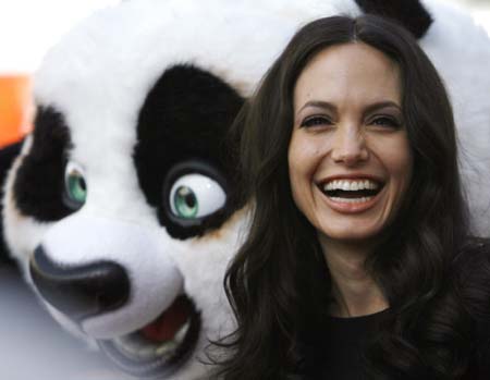 Cast member Angelina Jolie poses with a panda character during the DVD release of 