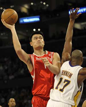 Yao Ming (L) of Houston Rockets passes the ball during the NBA game between Houston Rockets and Los Angeles Lakers at Staples Center in Los Angeles, CA, the United States, Nov. 9, 2008. [Xinhua] 