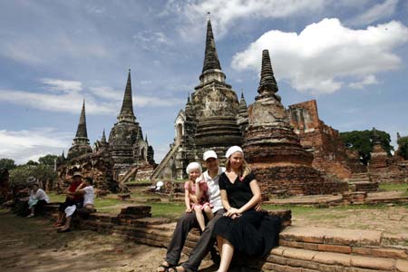  Tourists pose for a photo at a historical remains in Ayutthaya province of Thailand, Nov. 6, 2008. Thai tourism is expected to lose 1.5-2.1 billion U.S. dollars if the country's polictical crisis lasts till the end of the year, according to a Thailand-based research center. Tourism earned for Thailand 23.5 billion dollars in 2007. (Xinhua Photo/Liu Lianfen)