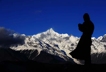 A man of the Tibetan ethnic group prays toward the Meili Snow Mountain in Deqin, southwest China's Yunan Province, Nov. 4, 2008.(Xinhua/Zou Zheng) 