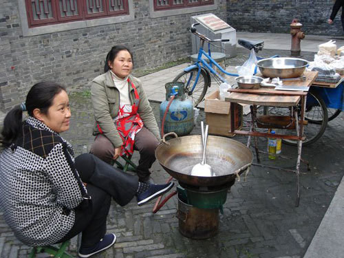 This undated photo shows two women selling snacks in Yangzhou, a city in east China's Jiangsu Province. [Photo: CRIENGLISH.com]