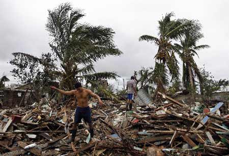 People stand on the ruins of their houses destroyed by Tropical Storm Paloma in Santa Cruz del Sur Camaguey, Cuba November 9, 2008.