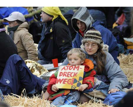 A child holds a sign reading &apos;go away with the waste&apos; during a sit-in outside Germany&apos;s interim nuclear waste storage facility in the northern German village of Gorleben November 10, 2008.