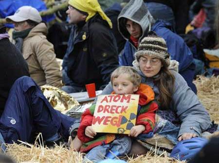 A child holds a sign reading 'go away with the waste' during a sit-in outside Germany's interim nuclear waste storage facility in the northern German village of Gorleben November 10, 2008. [Xinhua/Reuters]