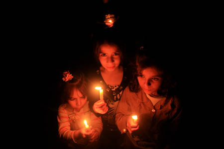 Palestinian children participate in a candle-light demonstration after Gaza plunged into darkness on Nov. 10, 2008. The only power station in Gaza Strip was forced to shut down on Monday due to the Israeli blockade of fuel deliveries, leaving 800,000 people into blackout. (Xinhua Photo)